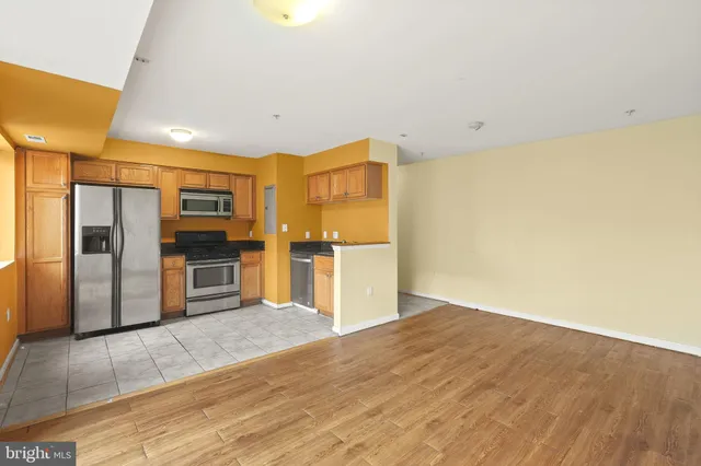 a kitchen with stainless steel appliances a refrigerator and a stove top oven