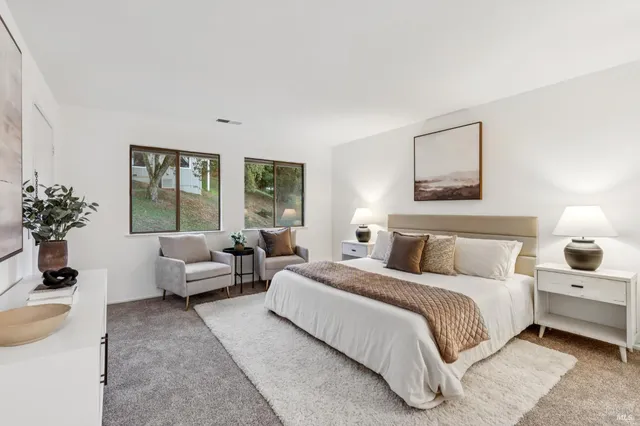 a bedroom with bed couch and window