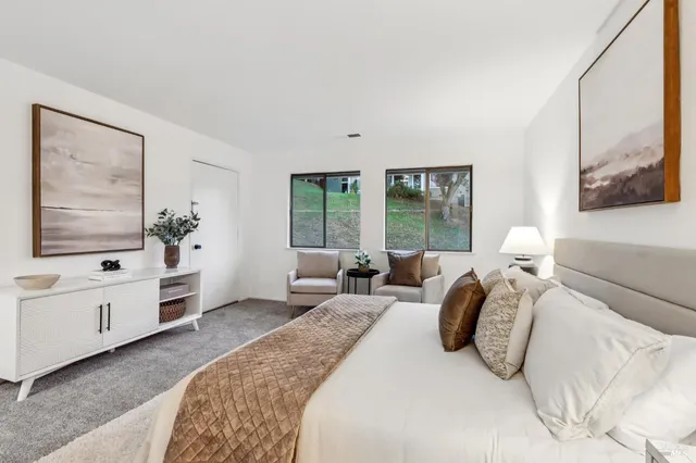 a bedroom with a large bed and wooden floor