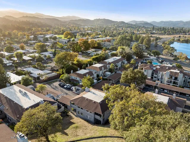 an aerial view of residential houses with outdoor space and lake view