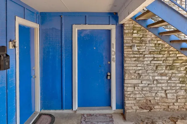 a view of an empty room with wooden floor and a ceiling fan