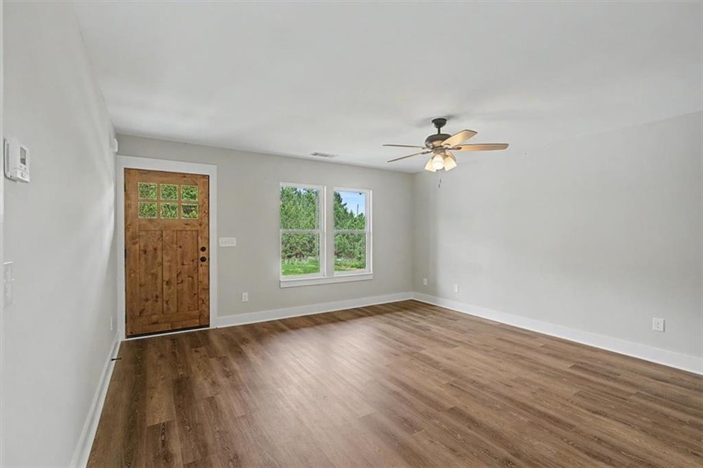 233 Old Old Alabama Road Southeast Emerson, GA 30137 - Photo 11 of 49 an empty room with wooden floor chandelier fan and windows