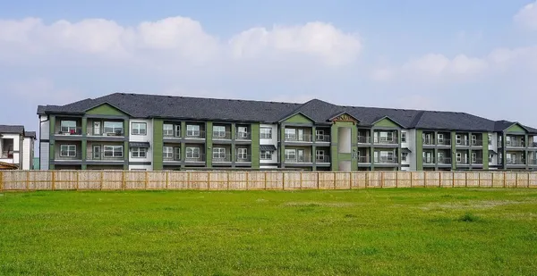 a front view of a residential apartment building with a yard