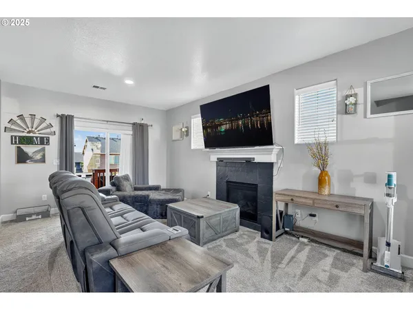 a living room with furniture a flat screen tv and a fireplace