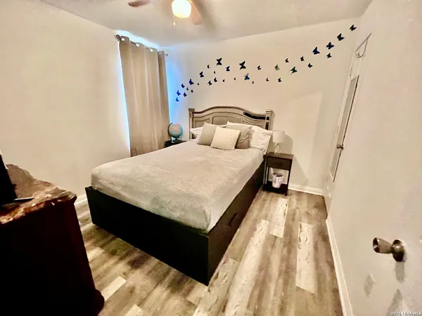 a bedroom with a bed and a flat tv screen on dresser