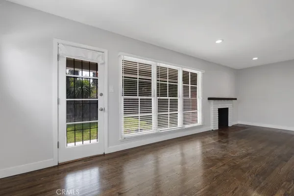 a view of a big room with wooden floor and windows