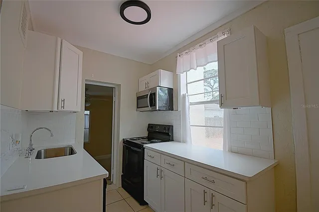 a kitchen with a sink appliances and cabinets