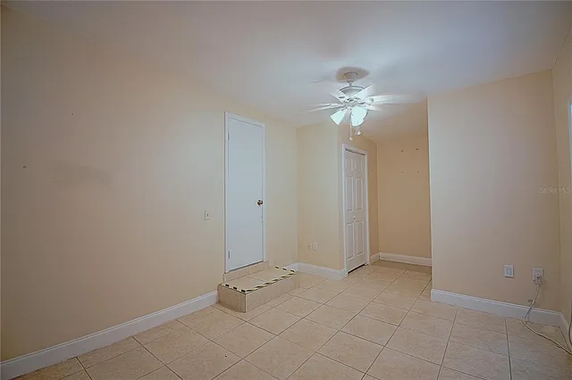 wooden floor in an empty room with a fan