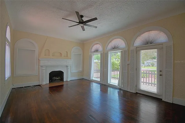 a view of empty room with fireplace and wooden floor