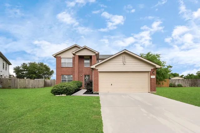 a front view of white house with a yard and garage