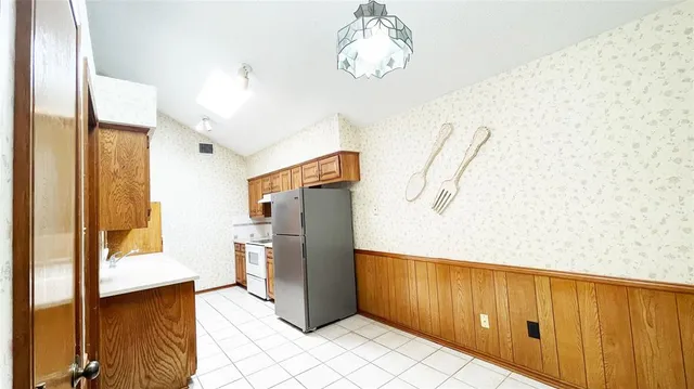 a kitchen with stainless steel appliances a refrigerator and a stove top oven