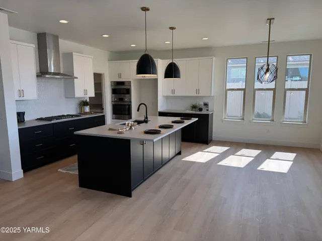 a kitchen with stainless steel appliances granite countertop a sink a stove and a refrigerator