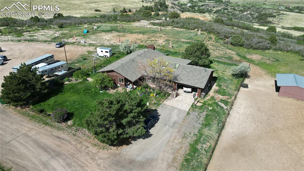 1245 South Ridge Road Castle Rock, CO 80104 - Photo 34 of 39 an aerial view of a house with a yard and trees all around