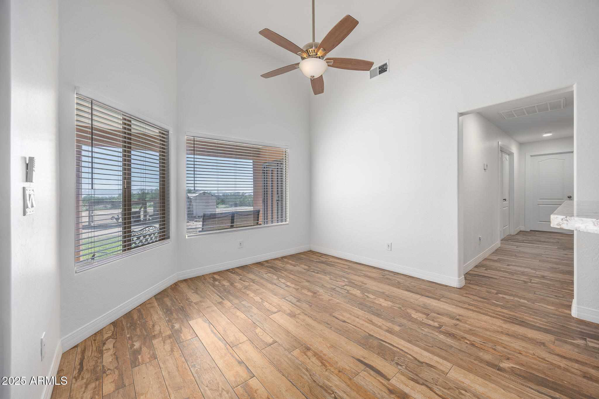 30826 North Crozier Road Wittmann, AZ 85361 - Photo 16 of 65 a view of an empty room with a window and wooden floor