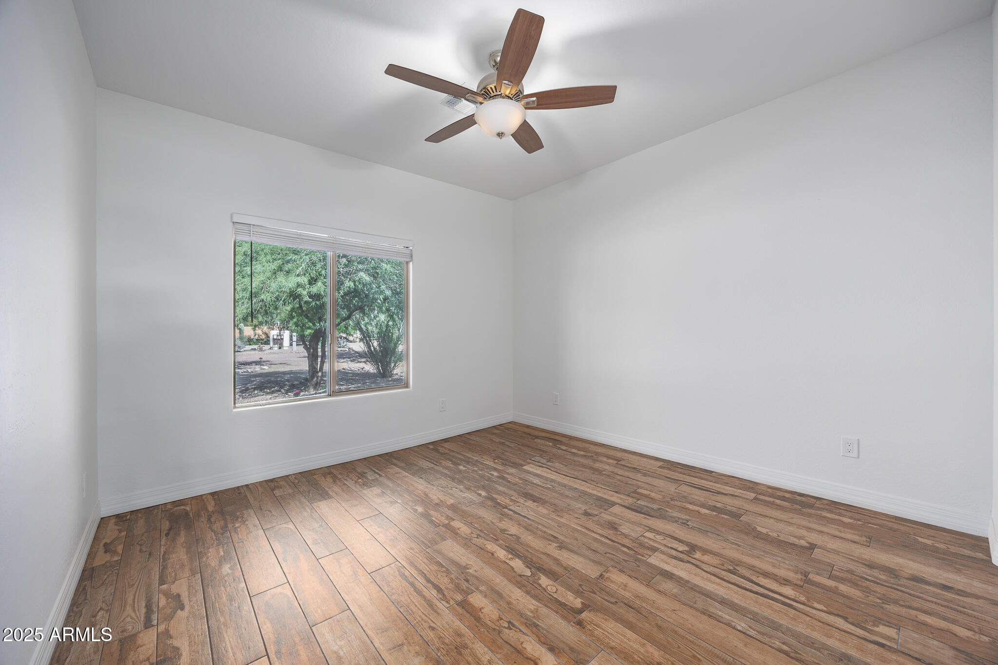 30826 North Crozier Road Wittmann, AZ 85361 - Photo 30 of 65 an empty room with wooden floor and windows