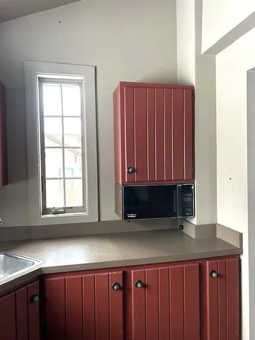 a kitchen with wooden cabinets a sink and a window