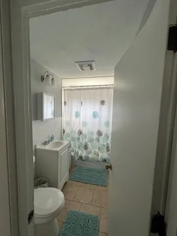 a bathroom with a granite countertop sink mirror vanity and toilet