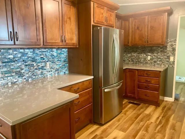 a kitchen with stainless steel appliances granite countertop a refrigerator and a stove