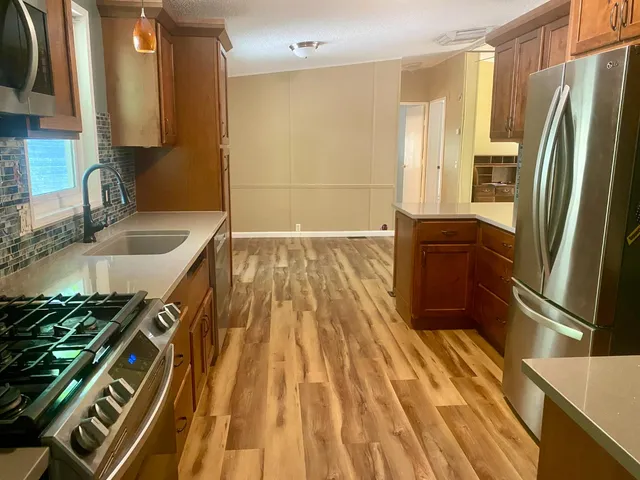 a kitchen with kitchen island granite countertop a sink and a refrigerator