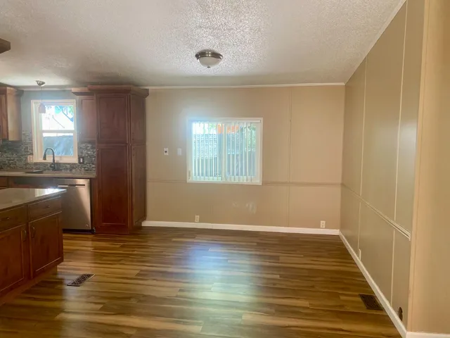 a view of a kitchen with wooden floor and a window