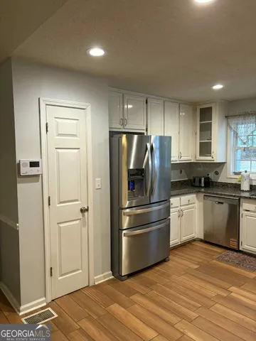 a kitchen with a refrigerator and a stove top oven