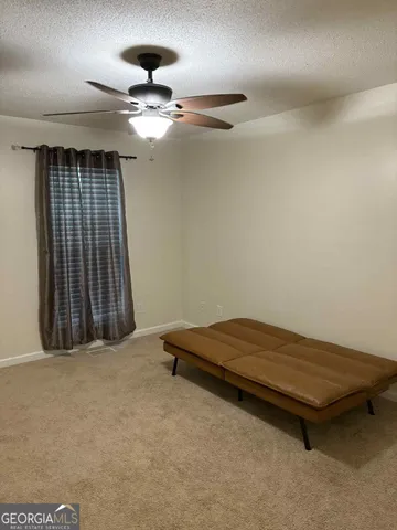 an empty room with windows and ceiling fan