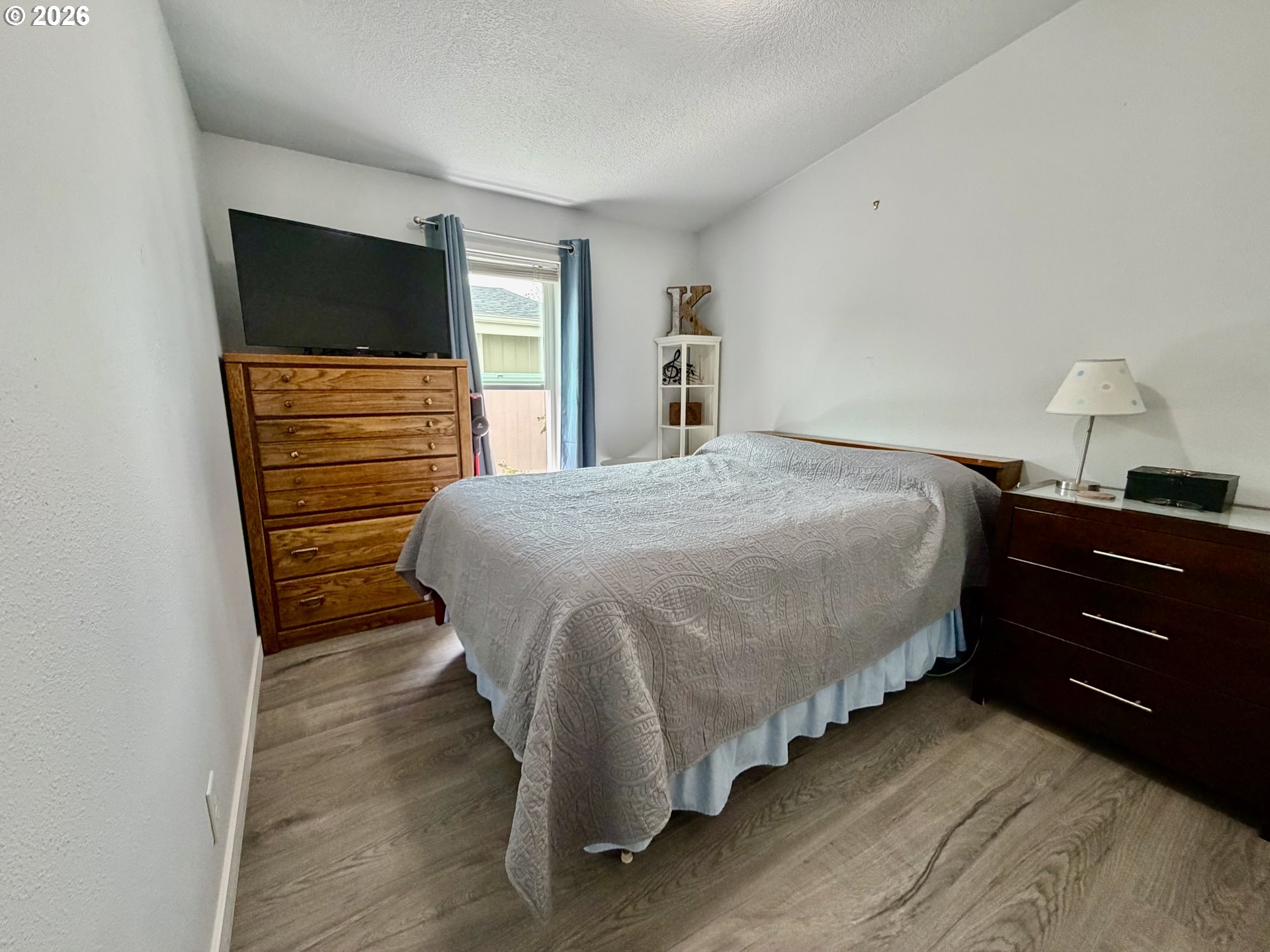 1699 North Terry Street, Unit 351 Eugene, OR 97402 - Photo 12 of 23 a bedroom with a bed and a flat tv screen on dresser