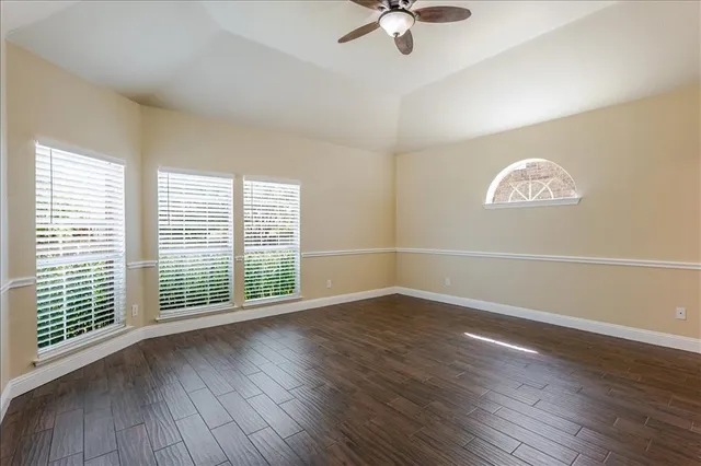 a view of a room with wooden floor chandelier and windows