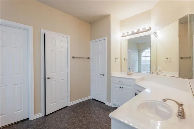 an empty room with wooden floor chandelier fan and windows