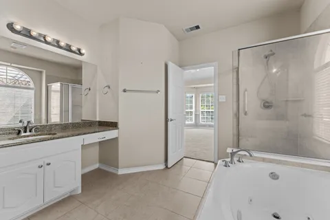 a bathroom with a tub sink and mirror