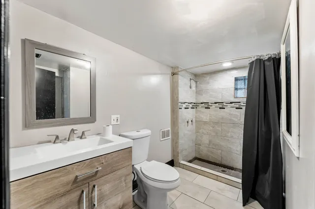 a bathroom with a granite countertop sink toilet and shower