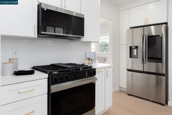 a kitchen with white cabinets and a refrigerator