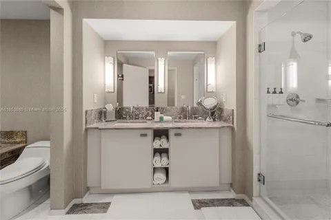 a bathroom with a granite countertop sink mirror vanity and toilet