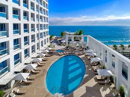 a front view of a house with swimming pool having outdoor seating
