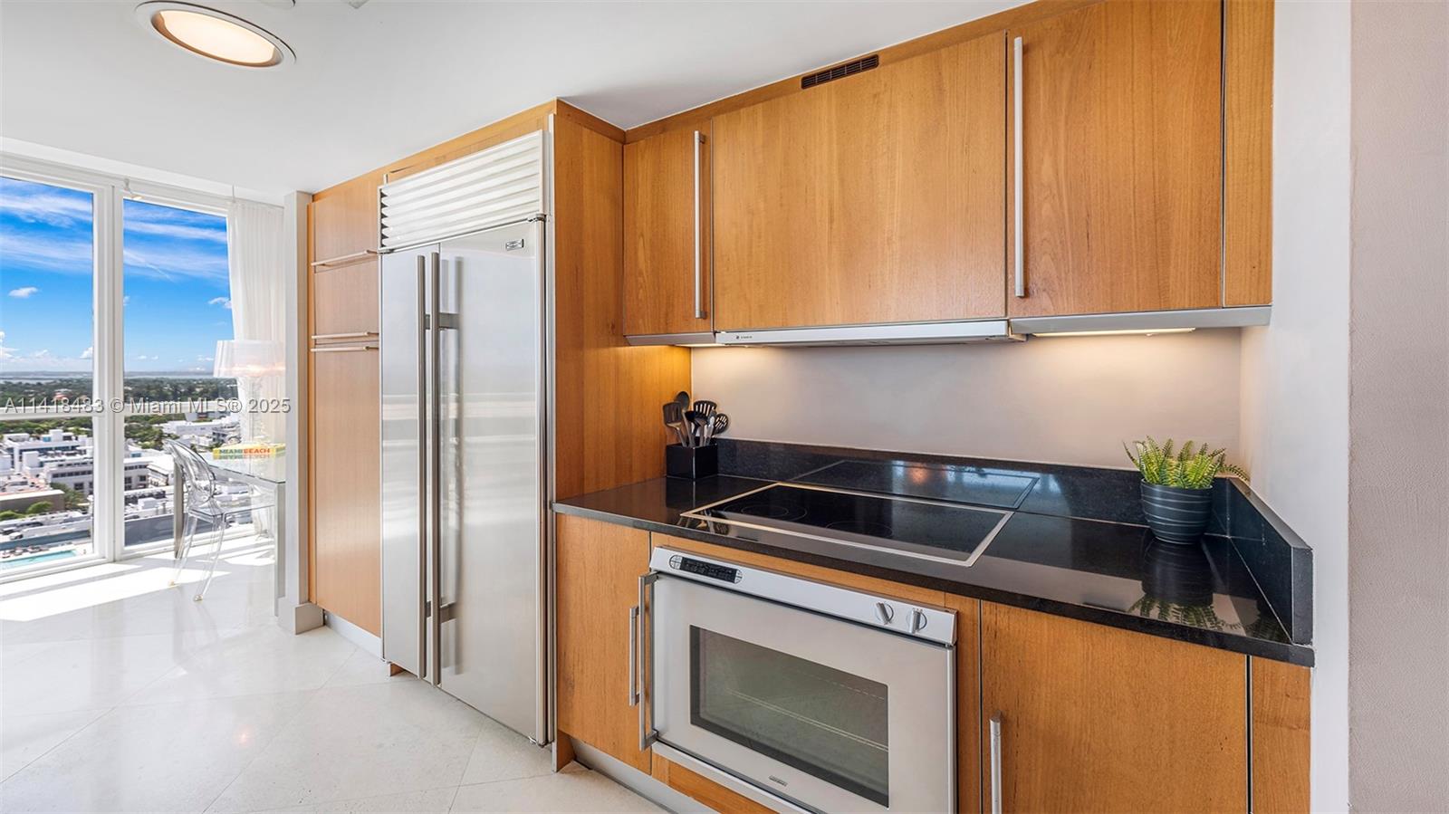 101 20th Street, Unit 2102 Miami Beach, FL 33139 - Photo 15 of 40 a kitchen with stainless steel appliances granite countertop a refrigerator a stove and a sink with cabinets