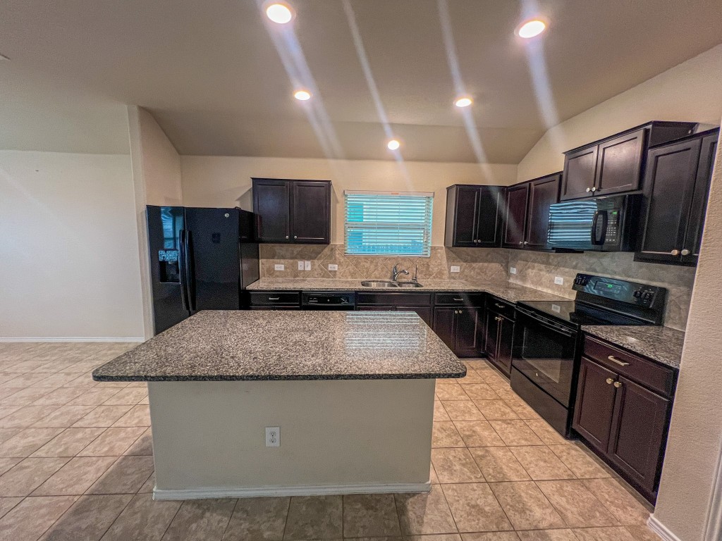 324 Druse Lane Jarrell, TX 76537 - Photo 12 of 29 a kitchen with stainless steel appliances granite countertop a sink stove microwave and refrigerator