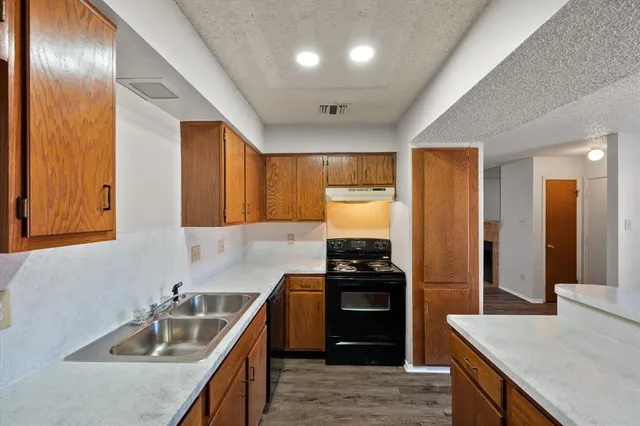 a kitchen with stainless steel appliances granite countertop a sink stove and refrigerator