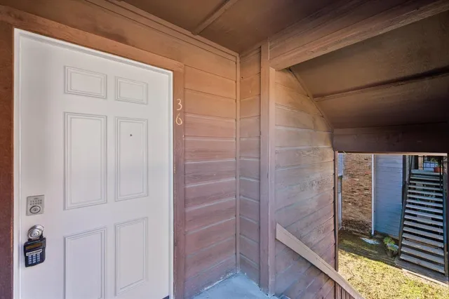 an empty room with wooden floor cabinet and windows