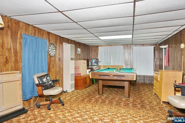 a room with pool table and windows