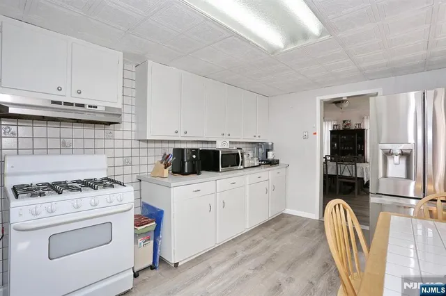 a kitchen with stainless steel appliances a stove a sink cabinets and a refrigerator