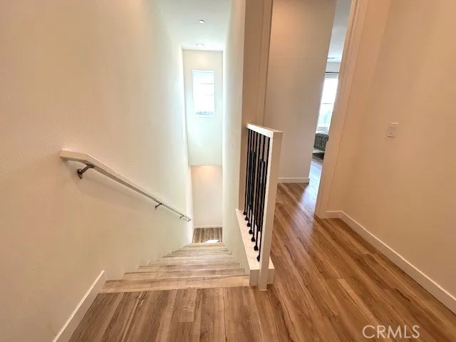 a view of a hallway with wooden floor and staircase