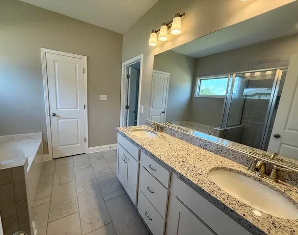 a spacious bathroom with a granite countertop sink a mirror and a