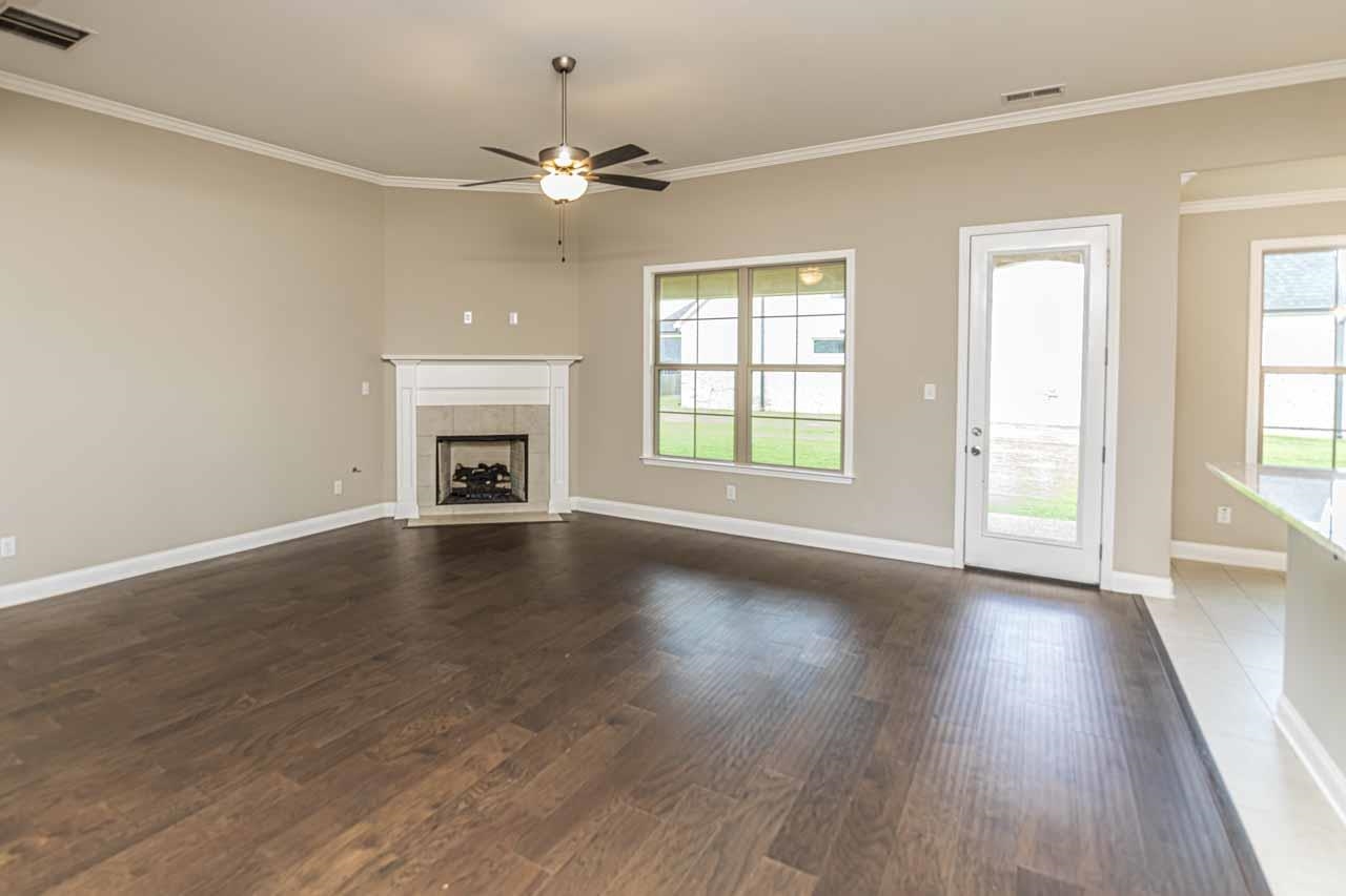 115 Misty Rdg Loop Oakland, TN 38060 - Photo 5 of 29 an empty room with wooden floor fireplace and windows