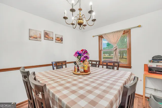 a dining room with furniture potted plants and wooden floor