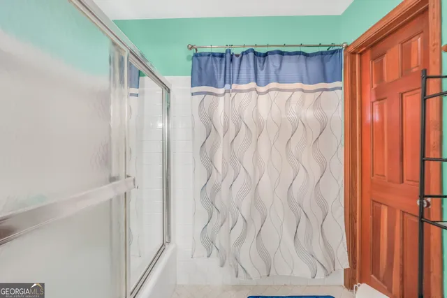 a bathroom with a shower curtain and a window