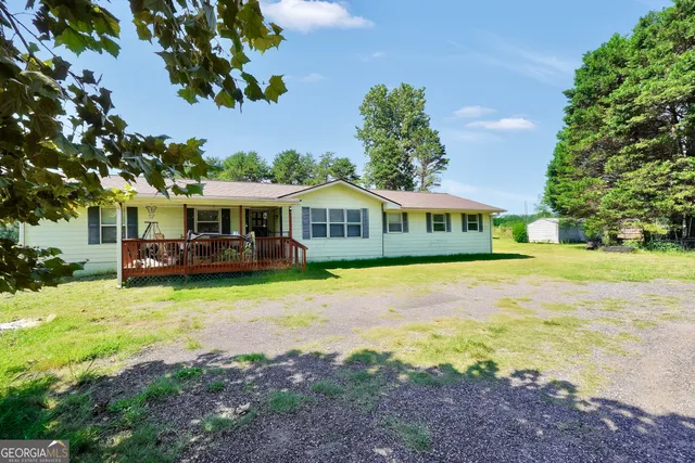 a front view of a house with yard patio and swimming pool