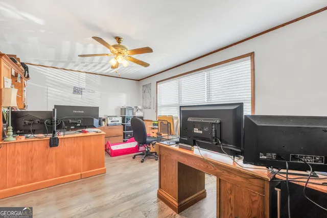 a living room with furniture a fireplace kitchen view and a flat screen tv