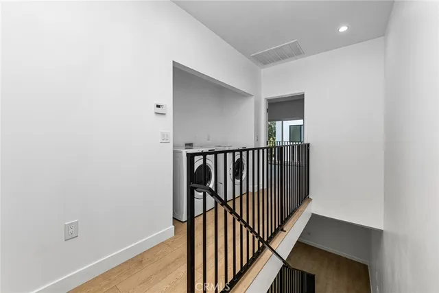 a view of a hallway with wooden floor and entryway