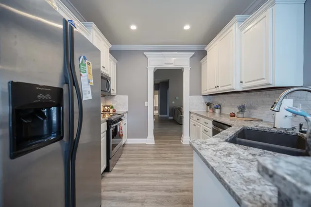a kitchen with stainless steel appliances granite countertop a sink stove and refrigerator