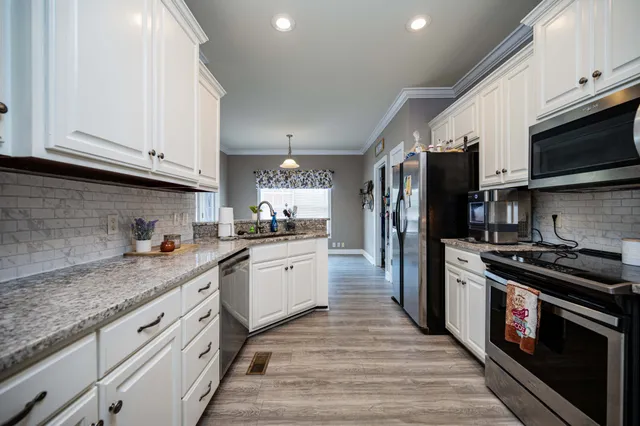a kitchen with granite countertop a refrigerator stove and microwave